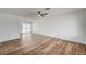 Spacious living room featuring wood-look flooring, ceiling fan, and sliding glass door to the backyard at 4047 Maple Hill Rd, Las Vegas, NV 89115