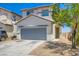 Two-story home with a gray garage door, gravel landscaping, and a cozy front entrance at 4118 Beech Family St, Las Vegas, NV 89115
