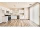 Bright kitchen with stainless steel appliances, white cabinetry, and expansive wood-look flooring at 4118 Beech Family St, Las Vegas, NV 89115