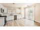 Well-lit kitchen showcasing stainless steel appliances, white cabinets, and sleek wood-look flooring at 4118 Beech Family St, Las Vegas, NV 89115