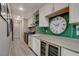 Spacious laundry room with modern washer/dryer, wine fridge, green tile backsplash and oversized clock at 4336 Guava Ct # 0, Las Vegas, NV 89135
