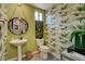 The powder room is decorated with unique wallpaper, a rope-framed mirror, and natural lighting at 4336 Guava Ct # 0, Las Vegas, NV 89135