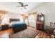 Comfortable bedroom features wood floors, a ceiling fan, and large windows with beautiful curtains at 4508 Dragon Fly Creek Ave, North Las Vegas, NV 89031