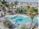 Aerial shot featuring a uniquely shaped pool enclosed by a black fence and palm trees at 4508 Dragon Fly Creek Ave, North Las Vegas, NV 89031