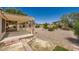 The backyard features a covered patio, gravel landscaping, and mature trees for added privacy at 4904 Meadows Encore Ave, Las Vegas, NV 89131