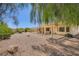 A large backyard features a gravel landscape, mature trees, and a covered patio at 4904 Meadows Encore Ave, Las Vegas, NV 89131