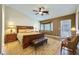 Spacious main bedroom with a sitting area, ceiling fan, and stylish furniture at 4904 Meadows Encore Ave, Las Vegas, NV 89131