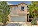 Two-story home featuring a two-car garage, desert landscaping, and a tile roof at 5004 Ironhorse Ranch Ave, Las Vegas, NV 89131