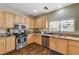 Well-lit kitchen showcasing wooden cabinets, granite countertops, and stainless steel appliances for modern living at 5004 Ironhorse Ranch Ave, Las Vegas, NV 89131