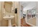 Neat half-bathroom with a pedestal sink, round mirror, and clean lines at 5004 Ironhorse Ranch Ave, Las Vegas, NV 89131