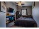 Bedroom featuring a ceiling fan, TV, gun safe, and a window at 5028 Crying Heart St, North Las Vegas, NV 89031