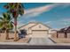 Charming single-story home featuring a two-car garage, desert landscaping, and mature palm trees at 5028 Crying Heart St, North Las Vegas, NV 89031