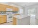 Well-lit kitchen featuring light-colored cabinets, an island, and access to the backyard at 5240 Adorato Dr, North Las Vegas, NV 89031