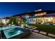 Outdoor oasis with a sparkling pool, spa, lush lawn, and views of city lights creating an entertainer's paradise at 527 Serenity Point Dr, Henderson, NV 89012