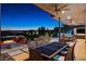 Backyard featuring dining and lounge area, pool, a modern fire pit, and stunning views of the surrounding landscape at 527 Serenity Point Dr, Henderson, NV 89012