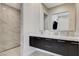 Bathroom featuring dual vanity, marble countertop, dark cabinetry, and a walk-in shower at 527 Serenity Point Dr, Henderson, NV 89012