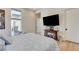 Bedroom featuring wood floors, wingback chair, a mounted television, and bright natural light at 527 Serenity Point Dr, Henderson, NV 89012
