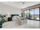 Spacious bedroom with a sitting area and a view of the patio and exterior landscaping at 527 Serenity Point Dr, Henderson, NV 89012
