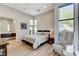 Bright bedroom boasts natural light, wood floors, ceiling fan, and ensuite bathroom access at 527 Serenity Point Dr, Henderson, NV 89012