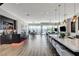 Spacious living room with open layout, modern kitchen, bar area, and access to outdoor seating with scenic views at 527 Serenity Point Dr, Henderson, NV 89012