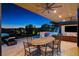 Covered outdoor dining space featuring a large table, comfortable seating, and views of the backyard and city at 527 Serenity Point Dr, Henderson, NV 89012