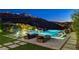 An inviting pool area with lounge chairs, manicured lawn, and breathtaking views of the hillside community at 527 Serenity Point Dr, Henderson, NV 89012