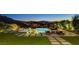 Backyard oasis with an infinity pool, lounge chairs, and lush landscaping, creating a serene retreat at 527 Serenity Point Dr, Henderson, NV 89012