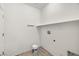 A simple laundry room with a shelf, hooks, and white walls at 5338 Lignum Ave, Pahrump, NV 89061