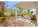 A backyard with desert landscaping with a covered patio featuring a BBQ, a swing and space for outdoor activities at 5539 Foxtail Ridge St, North Las Vegas, NV 89031