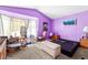 Purple bedroom featuring a large window, bench, and various furnishings at 5539 Foxtail Ridge St, North Las Vegas, NV 89031