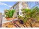 Exterior view of a two-story home's side showcasing mature trees and desert landscaping, enhancing curb appeal at 5539 Foxtail Ridge St, North Las Vegas, NV 89031