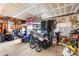 A cluttered garage with items stored haphazardly, a British flag on the wall, and a partially open garage door at 5539 Foxtail Ridge St, North Las Vegas, NV 89031