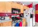 Functional kitchen with wood cabinets, stainless steel appliances, and red accent wall at 5539 Foxtail Ridge St, North Las Vegas, NV 89031
