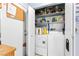 Laundry room with a side-by-side washer and dryer unit with shelving above, accessible through a door at 5539 Foxtail Ridge St, North Las Vegas, NV 89031
