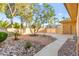 Landscaped backyard with rock features and mature trees, providing a serene and low-maintenance outdoor space at 5680 N Fort Apache Rd, Las Vegas, NV 89149