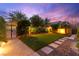 Backyard featuring manicured lawn, stepping stone path, a privacy fence and decorative landscaping at 5680 N Fort Apache Rd, Las Vegas, NV 89149