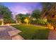 Lush backyard with privacy landscaping, manicured lawn, stone pathway, and a tranquil atmosphere at 5680 N Fort Apache Rd, Las Vegas, NV 89149