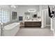 Luxurious bathroom featuring a soaking tub, double vanity, and contemporary fixtures at 5680 N Fort Apache Rd, Las Vegas, NV 89149