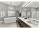 Luxurious bathroom with a soaking tub, glass block windows, and modern double vanity at 5680 N Fort Apache Rd, Las Vegas, NV 89149