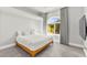 Bright bedroom featuring a natural wood bed frame and a large arched window with gray curtains at 5680 N Fort Apache Rd, Las Vegas, NV 89149