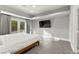 Light-filled bedroom with gray walls, a mounted television, and sliding glass doors to the yard at 5680 N Fort Apache Rd, Las Vegas, NV 89149