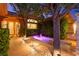 Inviting courtyard with lush landscaping, a tranquil water feature, and exterior ambient lighting at 5680 N Fort Apache Rd, Las Vegas, NV 89149