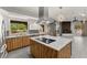 Contemporary kitchen with island cooktop and views of the fireplace and backyard at 5680 N Fort Apache Rd, Las Vegas, NV 89149