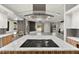Open concept kitchen featuring a marble island cooktop and stainless vent at 5680 N Fort Apache Rd, Las Vegas, NV 89149