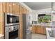 Modern kitchen featuring stainless steel appliances, wood cabinets, and a view of the outdoor area at 5680 N Fort Apache Rd, Las Vegas, NV 89149