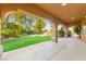 Covered patio offering a tranquil view of the lush backyard, perfect for outdoor lounging and entertaining at 5680 N Fort Apache Rd, Las Vegas, NV 89149