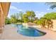 Beautiful backyard pool area with mature landscaping and serene waterfall feature at 5680 N Fort Apache Rd, Las Vegas, NV 89149