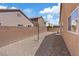 Low maintenance backyard with gravel, bordered by a brick wall and exterior of the home at 6041 Rosanna St, Las Vegas, NV 89113