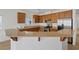 A kitchen with brown cabinets, stainless steel appliances, and a granite breakfast bar at 6041 Rosanna St, Las Vegas, NV 89113