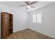 Neutral bedroom with a bookcase, ceiling fan, and window with plantation shutters at 6209 Lenaking Ave, Las Vegas, NV 89122
